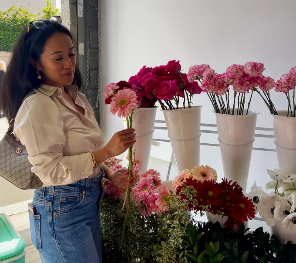 Dr. Kathleen Besas selecting pink flowers at a Los Angeles flower shop.