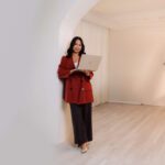 Brand strategist Denice Rabino working on her laptop in a bright studio