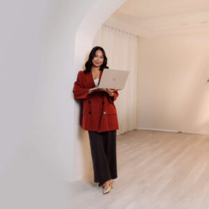 Brand strategist Denice Rabino working on her laptop in a bright studio