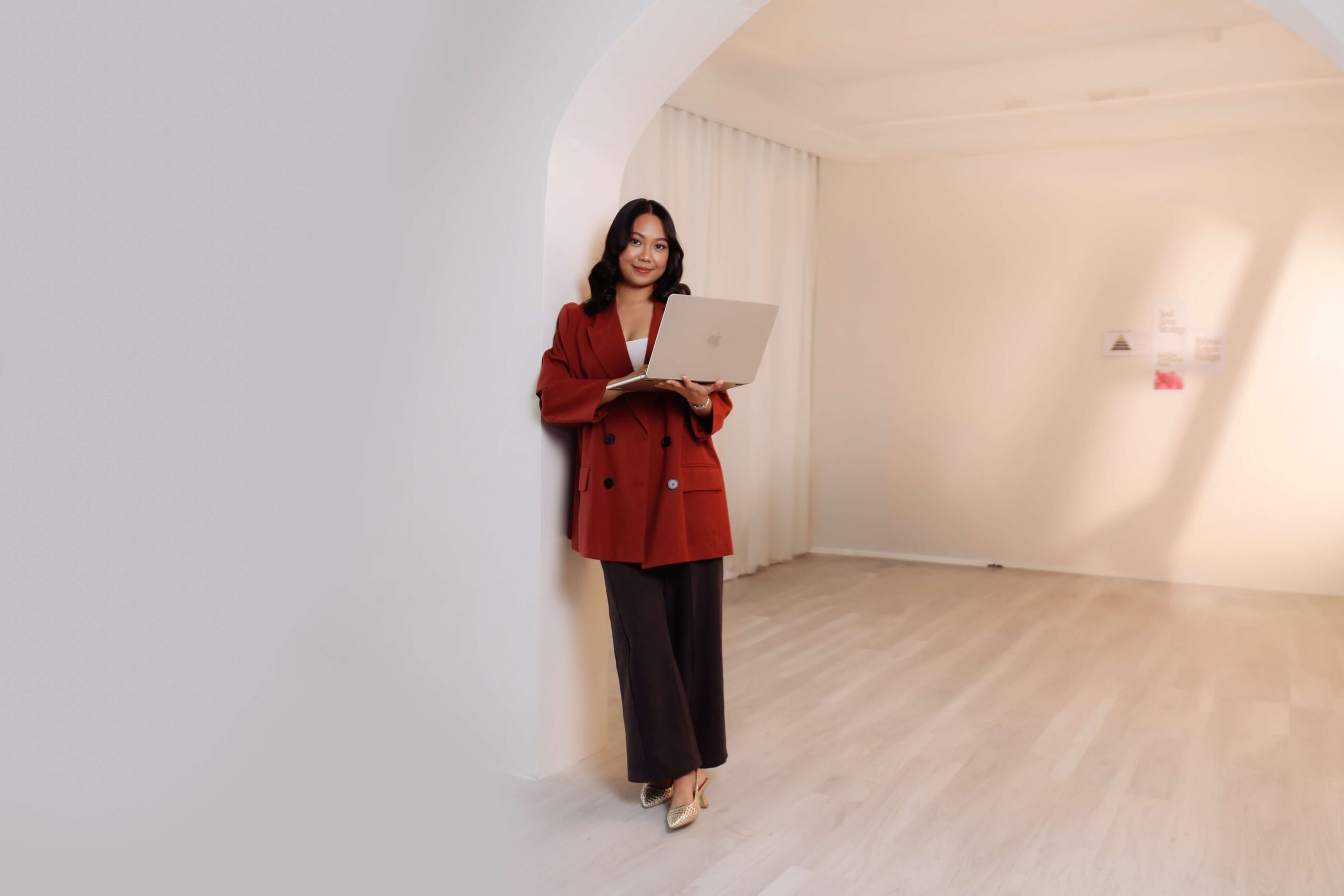 Brand strategist Denice Rabino working on her laptop in a bright studio